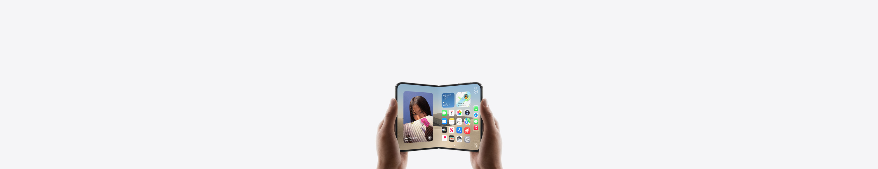 iPhone Duo, held by two hands in landscape orientation, unfolded, interior display features Home Screen