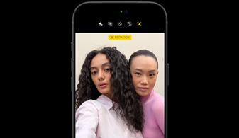 iPhone 18 Pro noir, de face, montrant deux personnes avec la fonctionnalité de suivi des visages, démonstration de la fonctionnalité Cadrage centré de la caméra avant