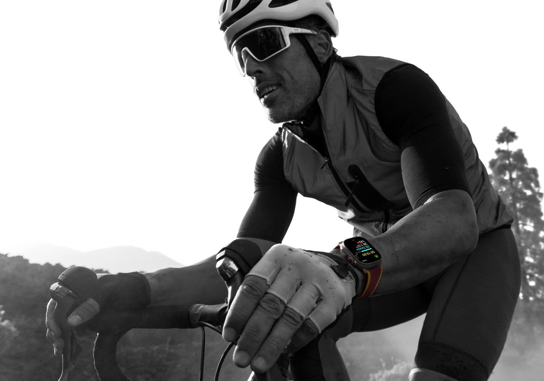 Osoba jedoucí na silničním kole s Apple Watch Ultra 4 na zápěstí, na displeji se zobrazují cyklistické ukazatele