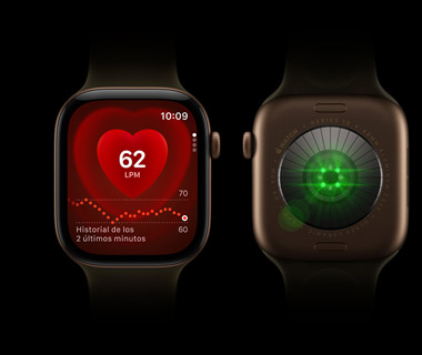 Dos Apple Watch Series 12 uno al lado del otro. Parte delantera del Apple Watch Series a la izquierda, la pantalla muestra el monitor de frecuencia cardiaca. Parte trasera del Apple Watch Series 12 a la derecha, luces brillantes, color verde.