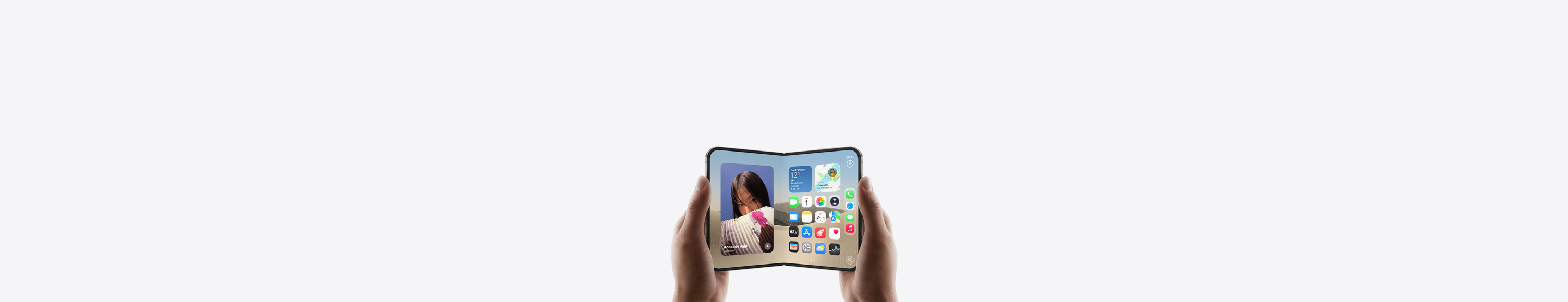 Due mani che tengono un iPhone Duo in orizzontale, aperto, si nota la schermata Home sul display