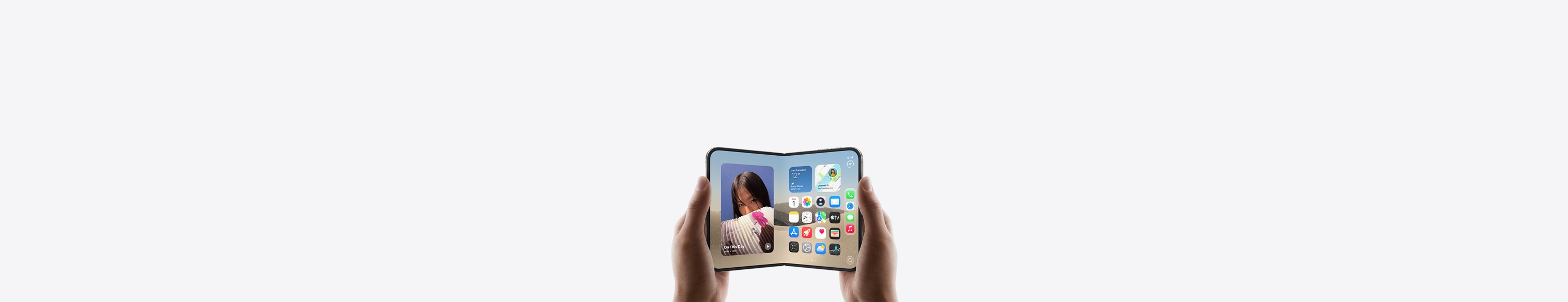 جهاز iPhone Duo، يدان تحملان الجهاز في الوضع الأفقي، مفتوح، الشاشة الداخلية تعرض الشاشة الرئيسية