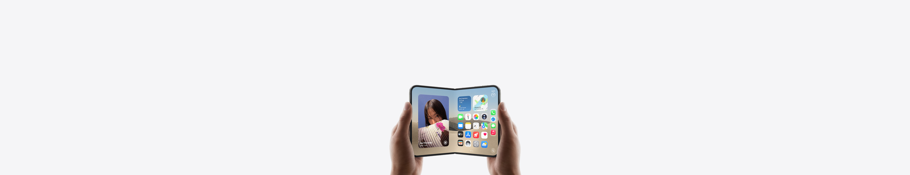 iPhone Duo, held by two hands in landscape orientation, unfolded, interior display features Home Screen