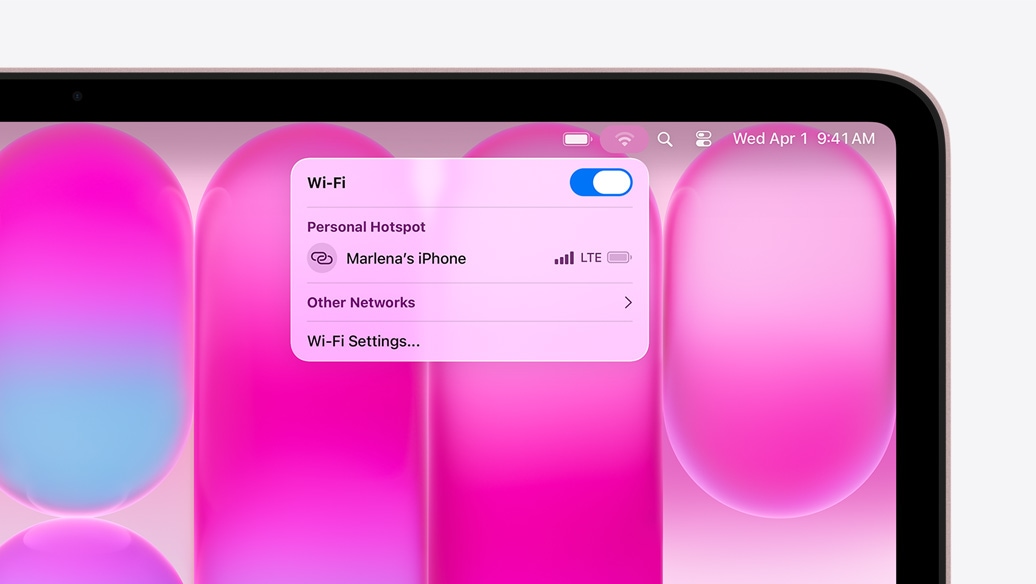 MacBook Neo, rumencová farba. Ponuka Wi‑Fi ukazuje sekciu Osobný hotspot s možnosťou „Marlenin iPhone“ na výber.
