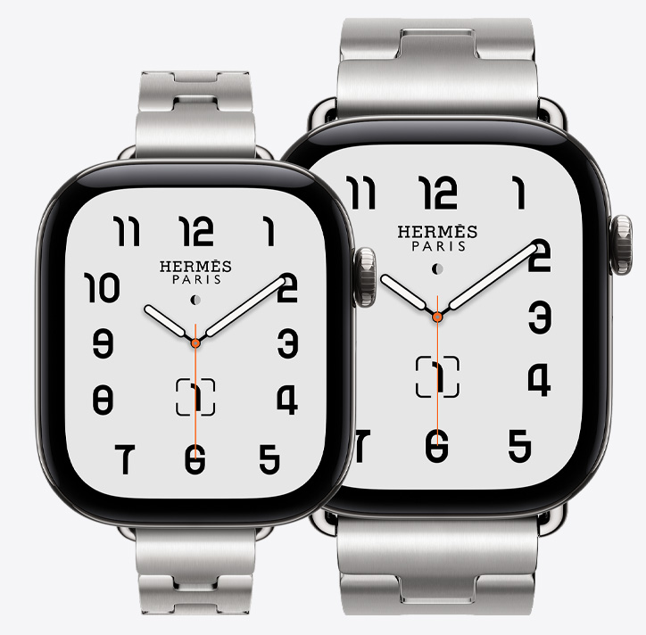 Apple Watch Hermès Series 12, both 42mm and 46mm models shown, Classic analog watch face (hour, minute, and second hands, complications: lunar phase, date), titanium case, silver color, 42mm paired with Grand H Fin band, satiné color, 46mm paired with Grand H band, satiné color