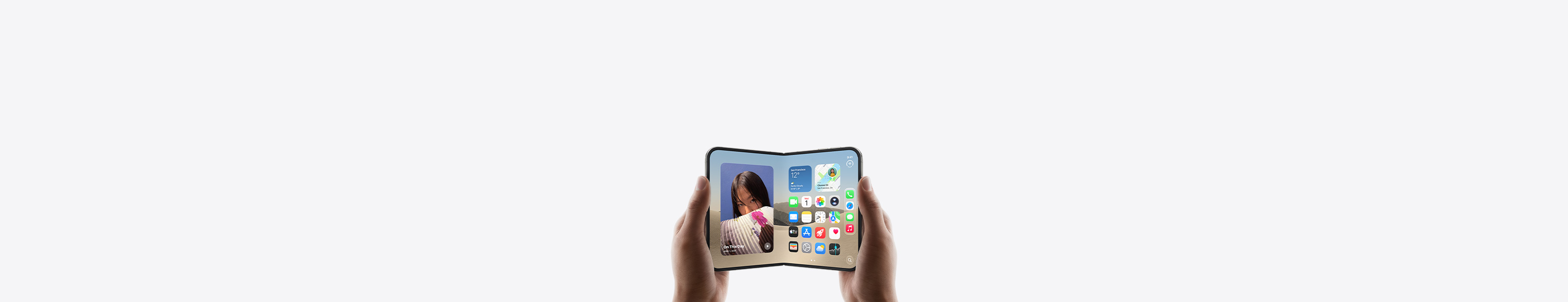 iPhone Duo, held by two hands in landscape orientation, unfolded, interior display features Home Screen